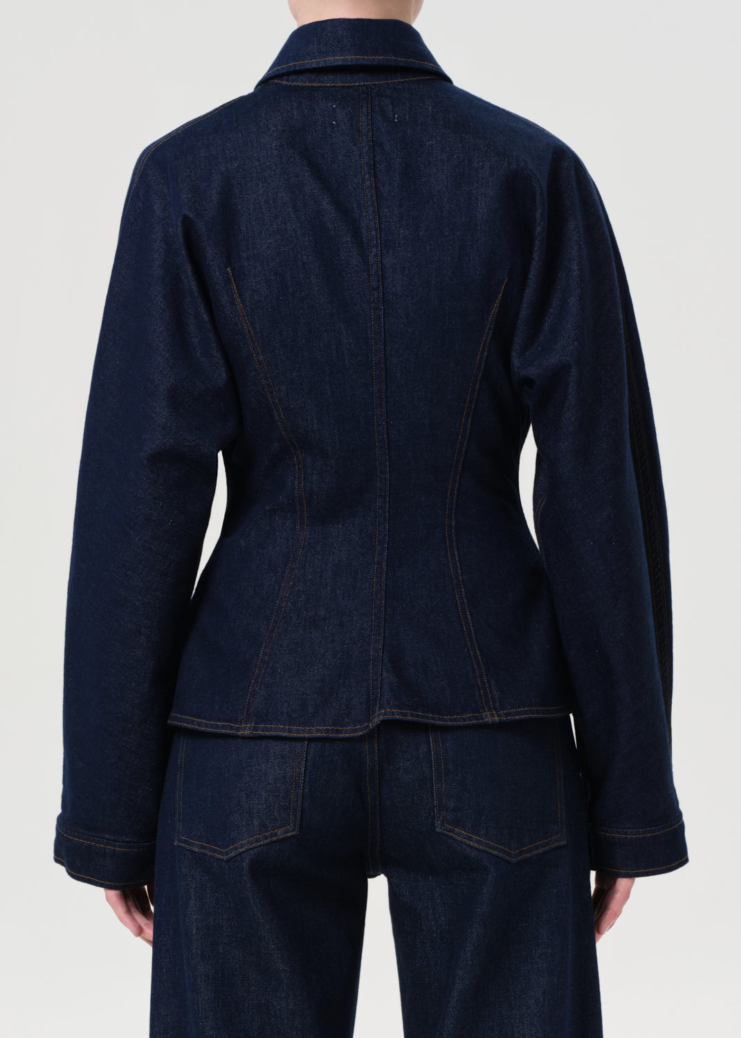 Dark denim jacket and pants on a plain background