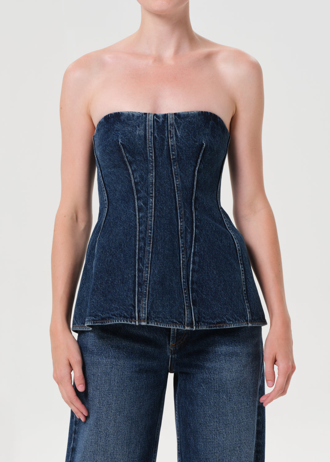 Denim strapless top worn by a model on a white background