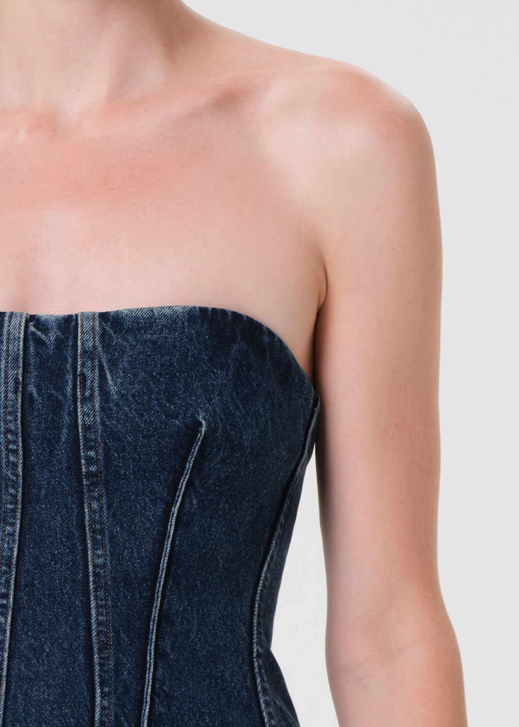 Denim strapless top worn by a person on a plain background