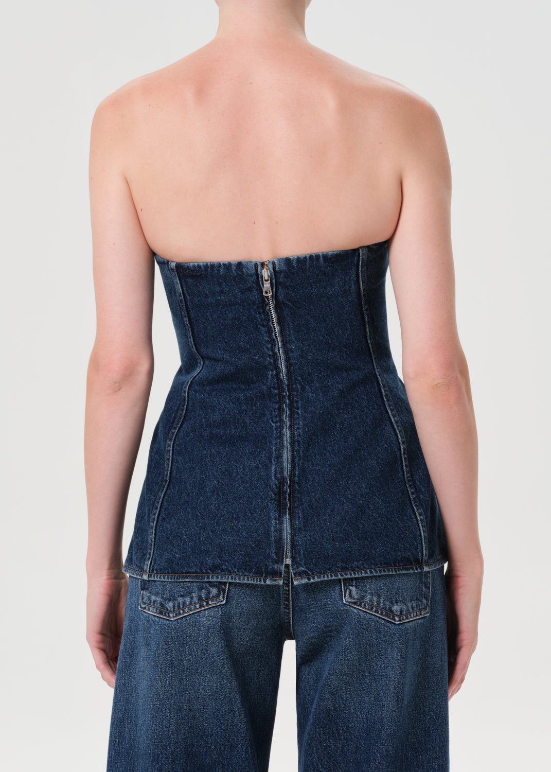Denim strapless top worn by a person on a plain background