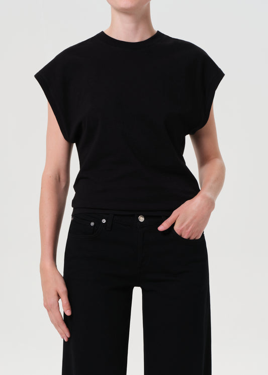 Person wearing a black sleeveless top and black pants on a white background