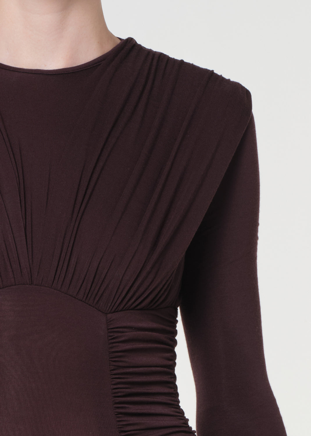 Brown long-sleeve dress with a draped design on a white background