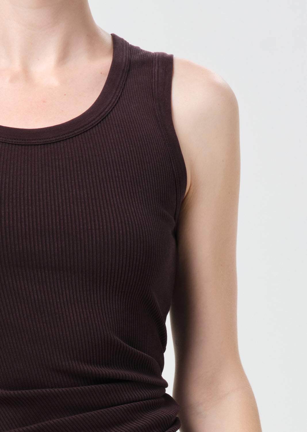 Brown ribbed tank top worn by a person on a light gray background