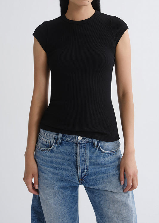 Person wearing a black t-shirt and blue jeans on a grey background