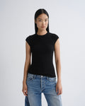 A model wearing a fitted black short-sleeve crewneck top and light wash blue jeans, standing against a light gray studio background.