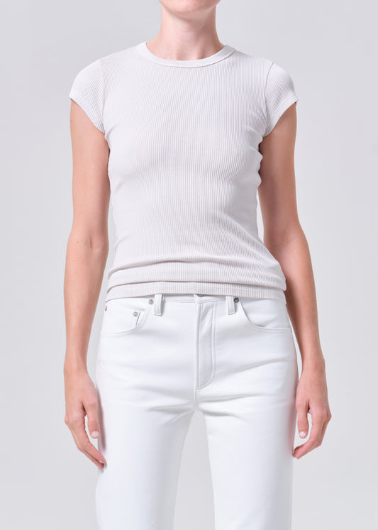 Person wearing a plain white t-shirt and pants on a light gray background