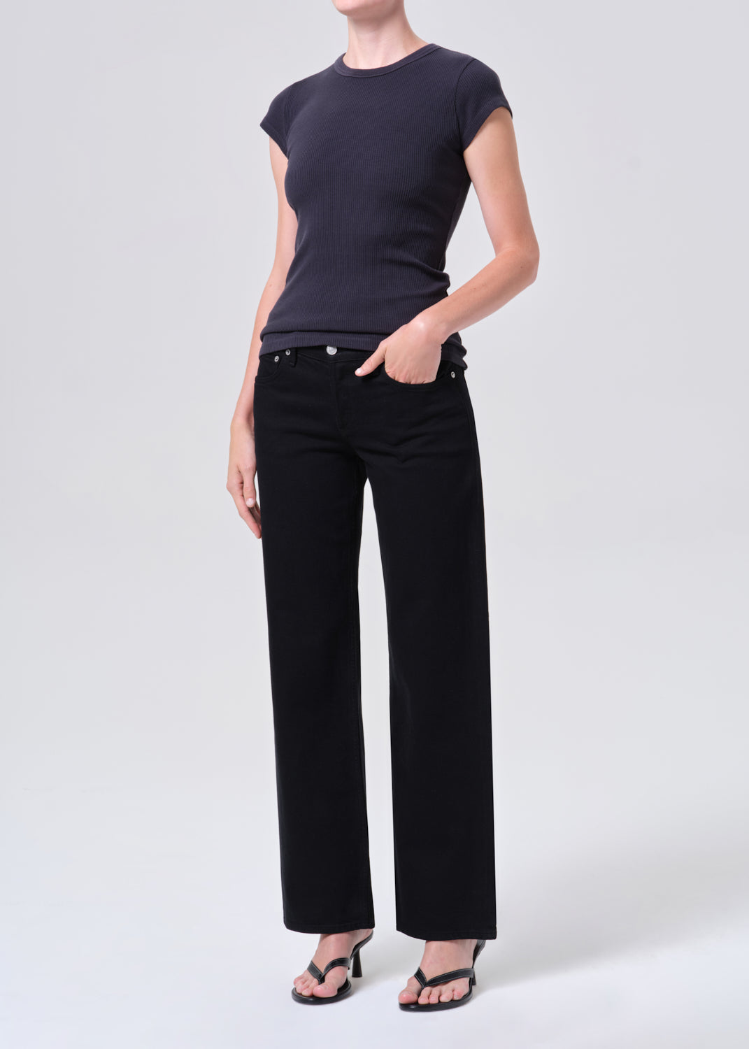 Person wearing a black t-shirt and black pants on a white background