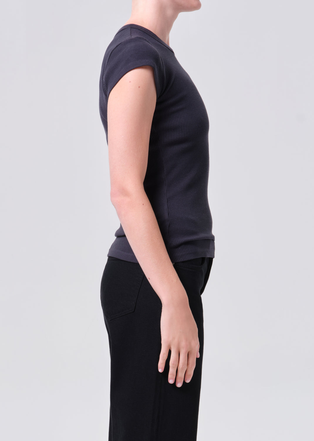 Person wearing a dark blue t-shirt and black pants on a light gray background