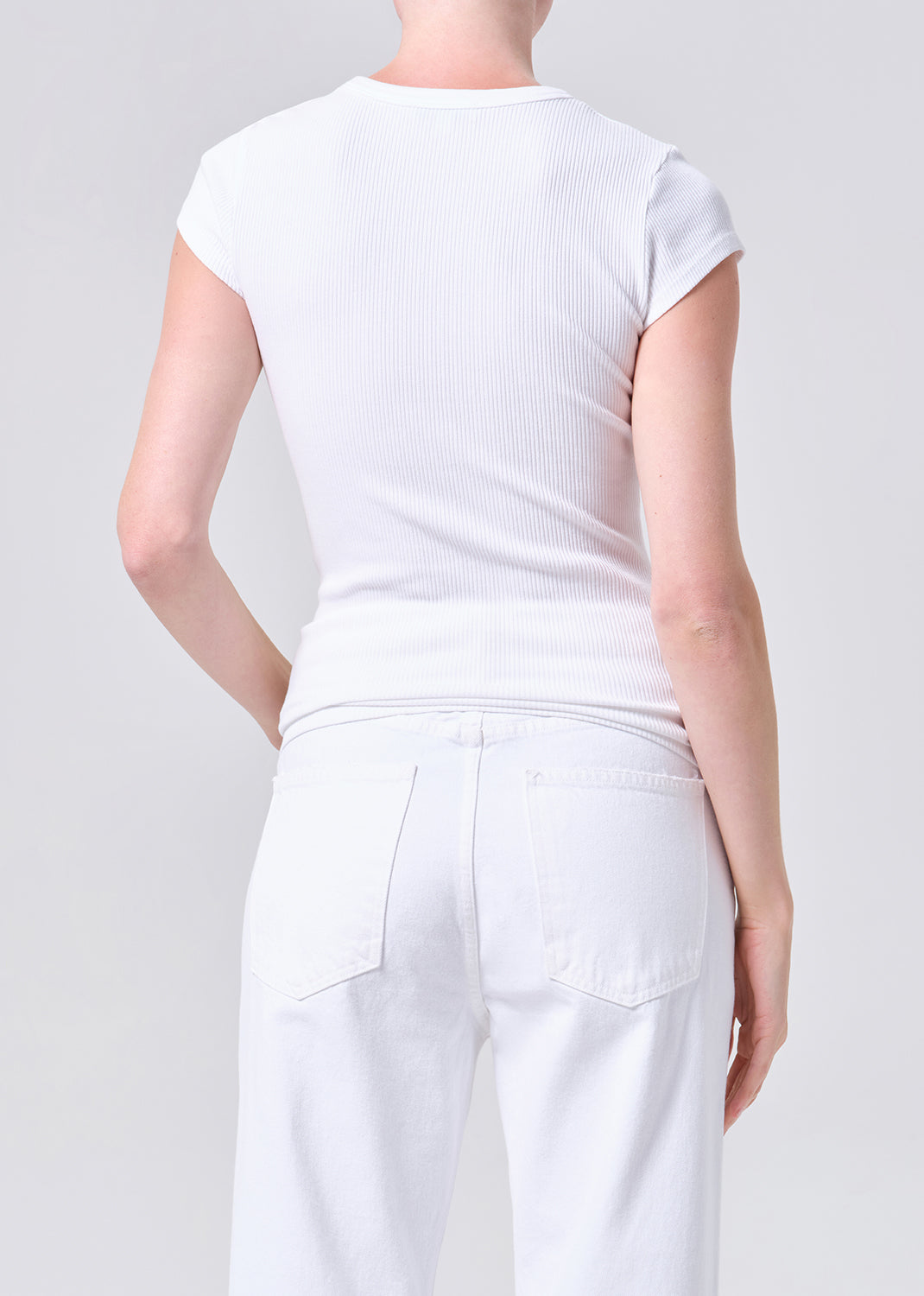 Person wearing a white t-shirt and pants on a plain background