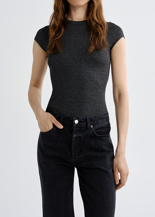 Person wearing a black t-shirt and black jeans on a white background