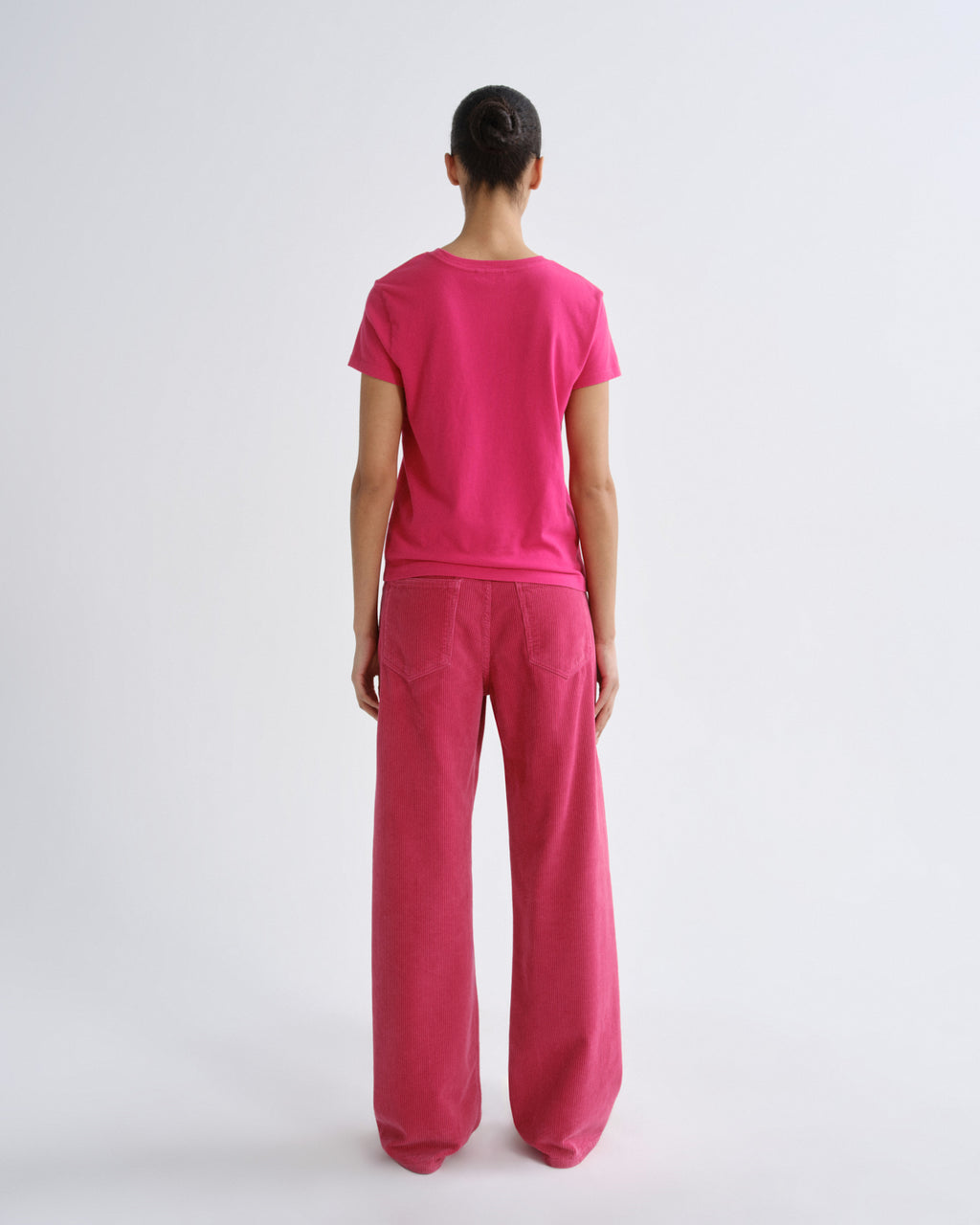 Person wearing a pink outfit on a white background
