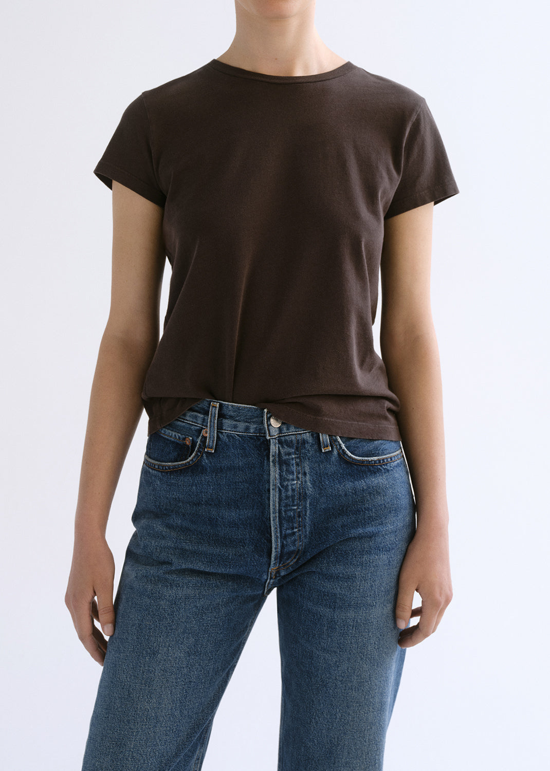 Person wearing a brown shirt on a grey background