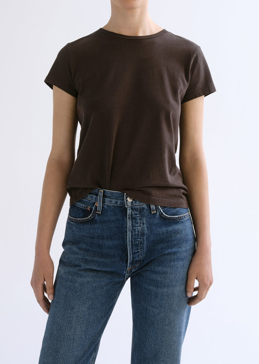 Person wearing a brown shirt on a grey background
