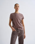 Person wearing a brown t-shirt and pants against a white background