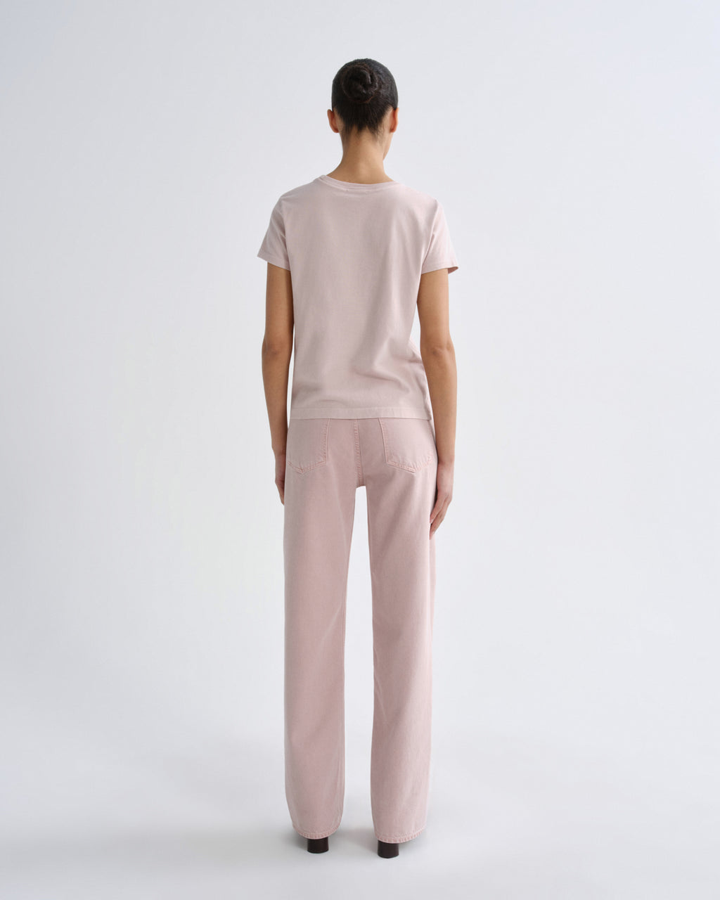 Woman wearing a light pink outfit on a white background