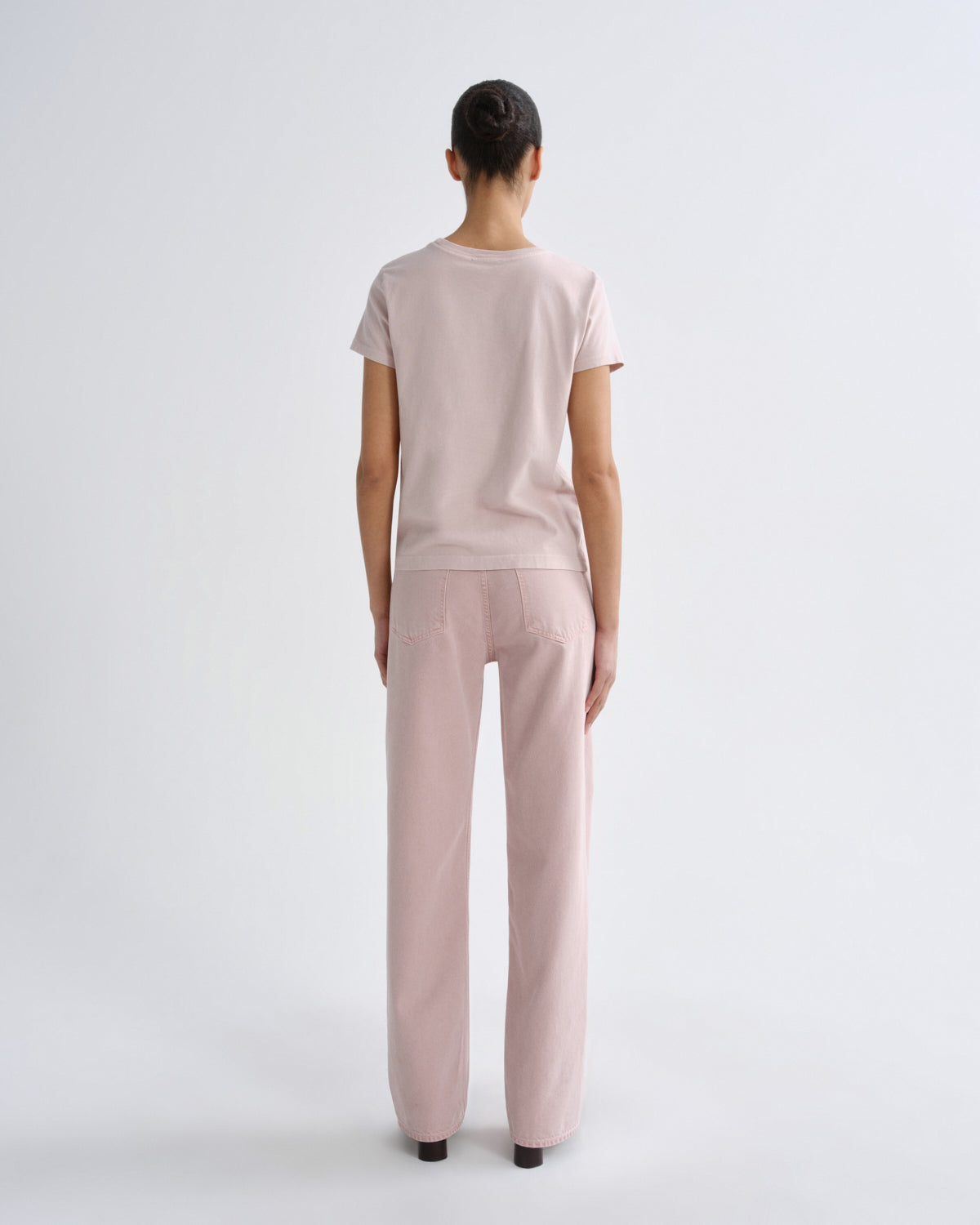Woman wearing a light pink outfit on a white background