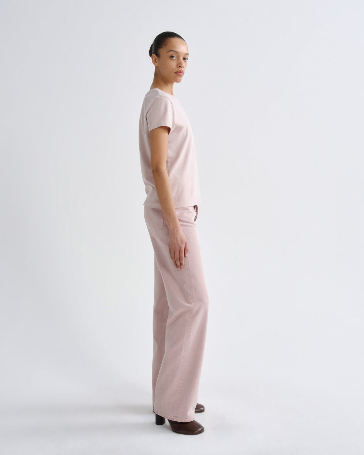 Person wearing a light pink outfit on a white background