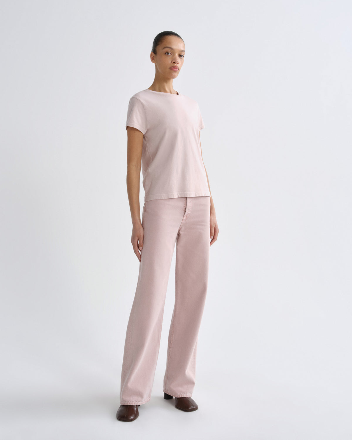 Woman wearing a light pink outfit on a white background