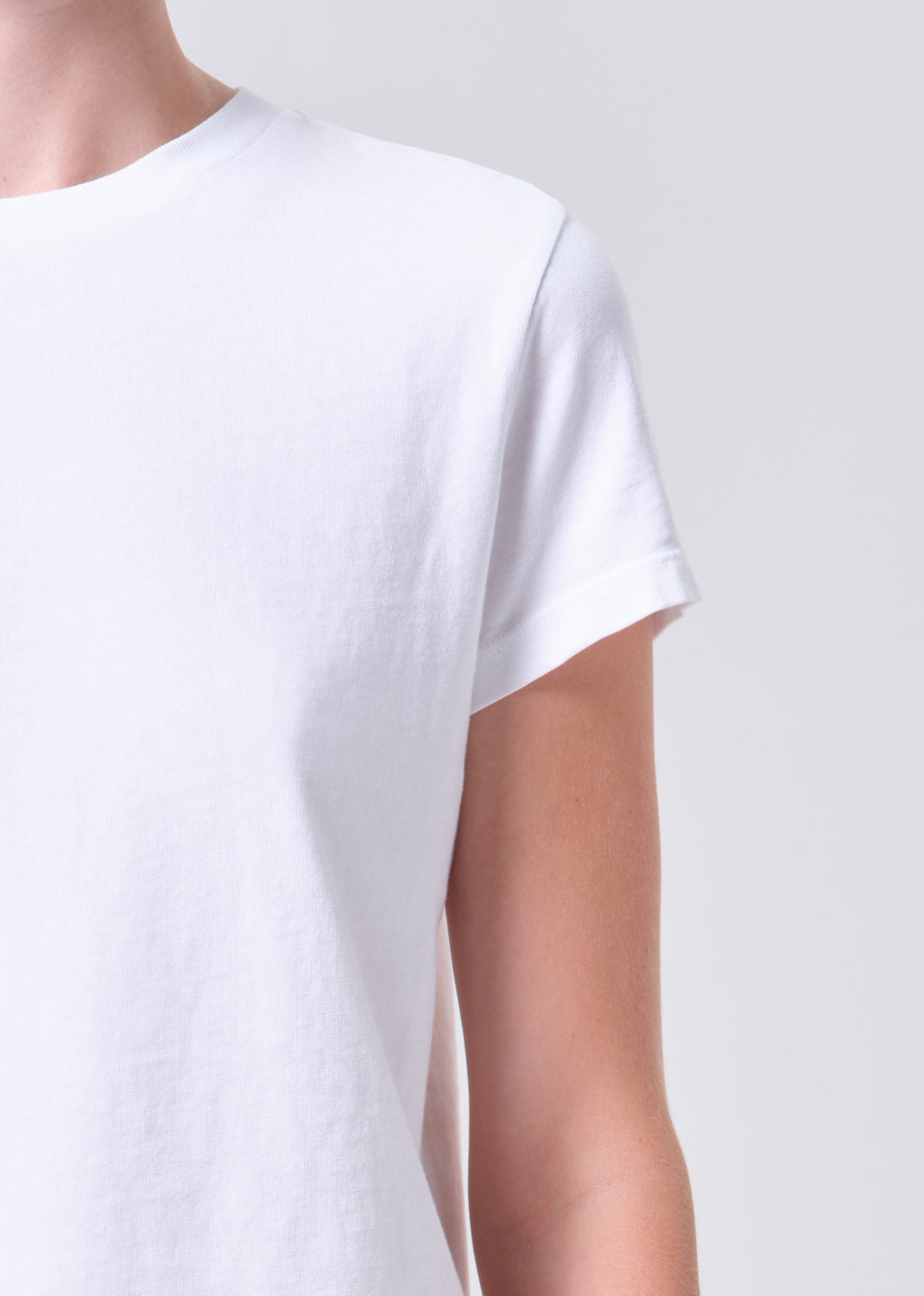 White t-shirt worn by a person on a plain background