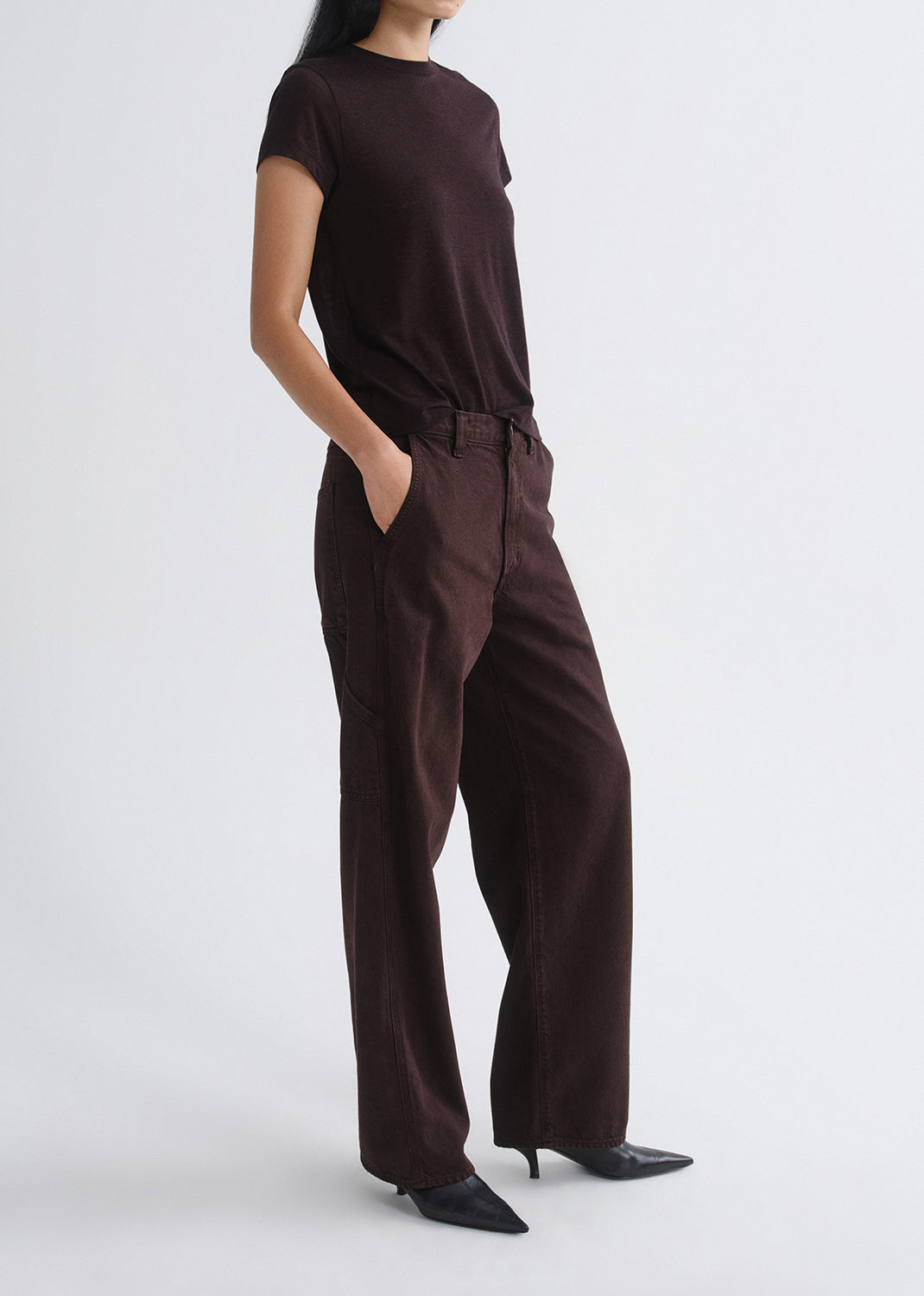 Person wearing a brown outfit on a grey background