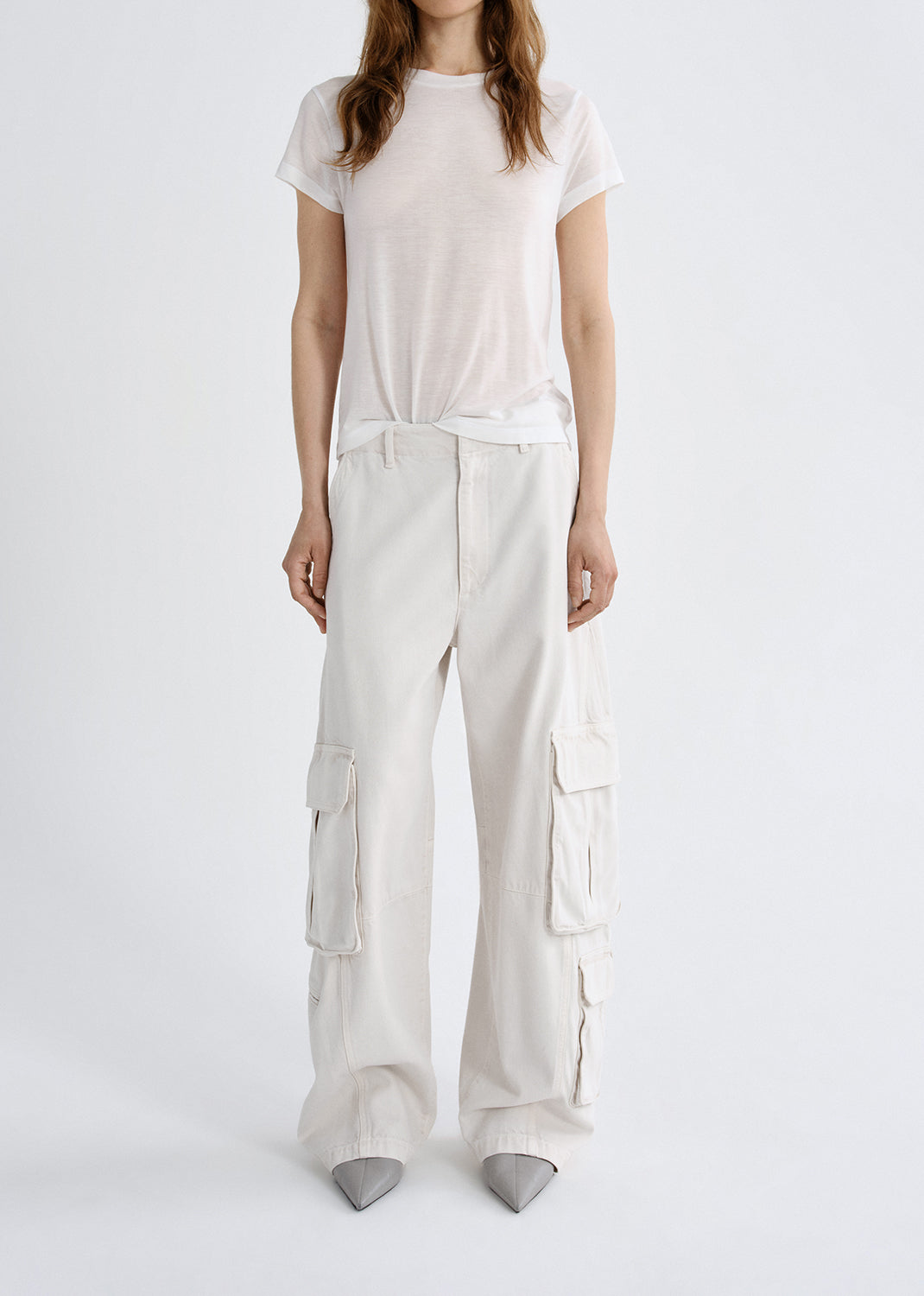Person wearing a white t-shirt and cargo pants on a grey background
