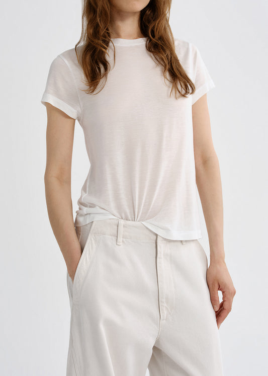 Person wearing a white t-shirt and pants on a grey background