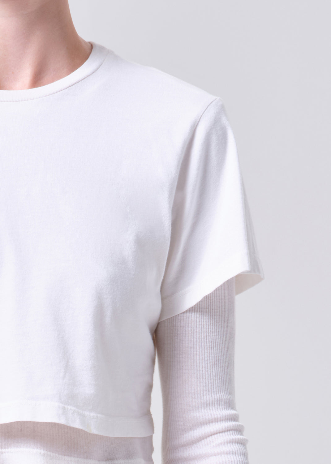 White long-sleeve shirt with sheer sleeves on a plain background