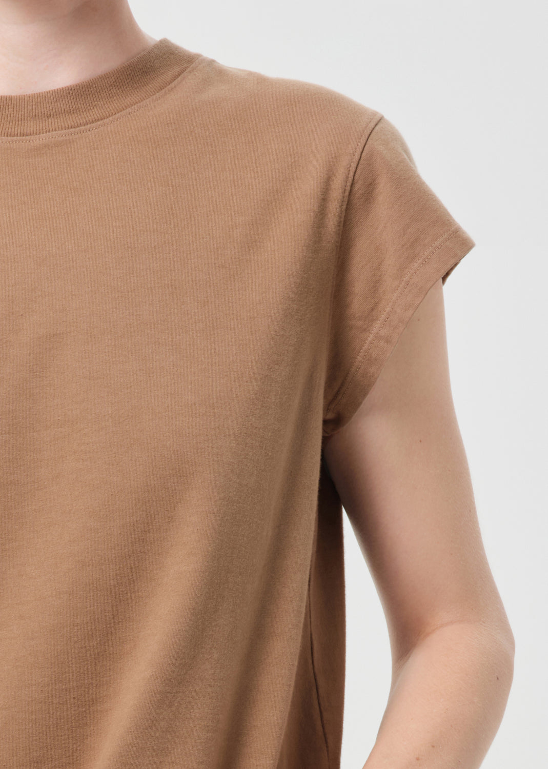Brown t-shirt worn by a person on a white background