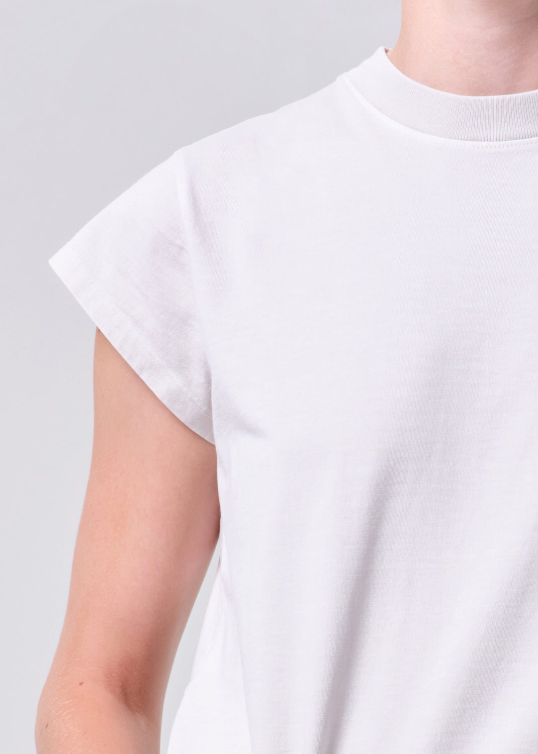 White t-shirt worn by a person on a gray background