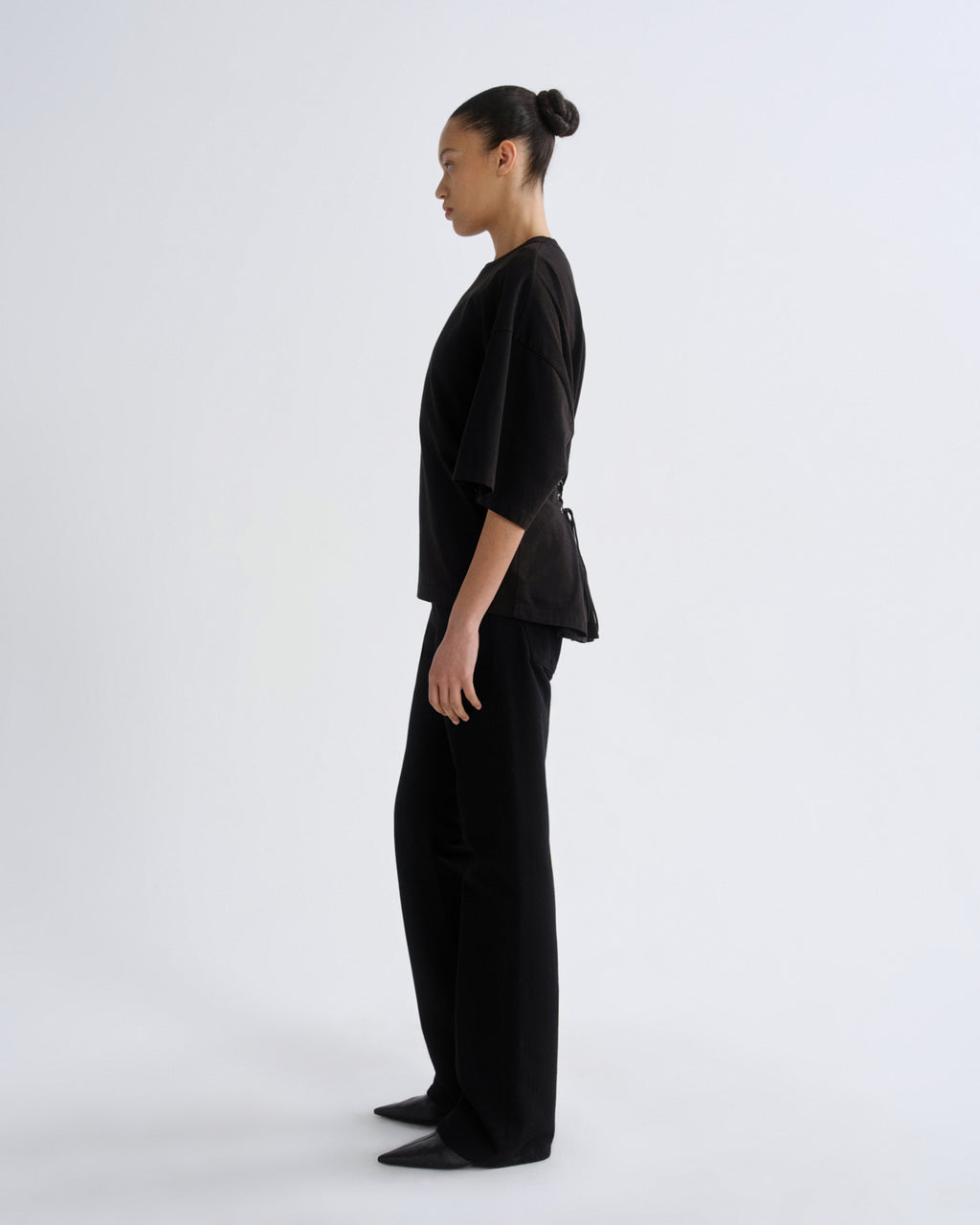 Person wearing a black outfit on a white background