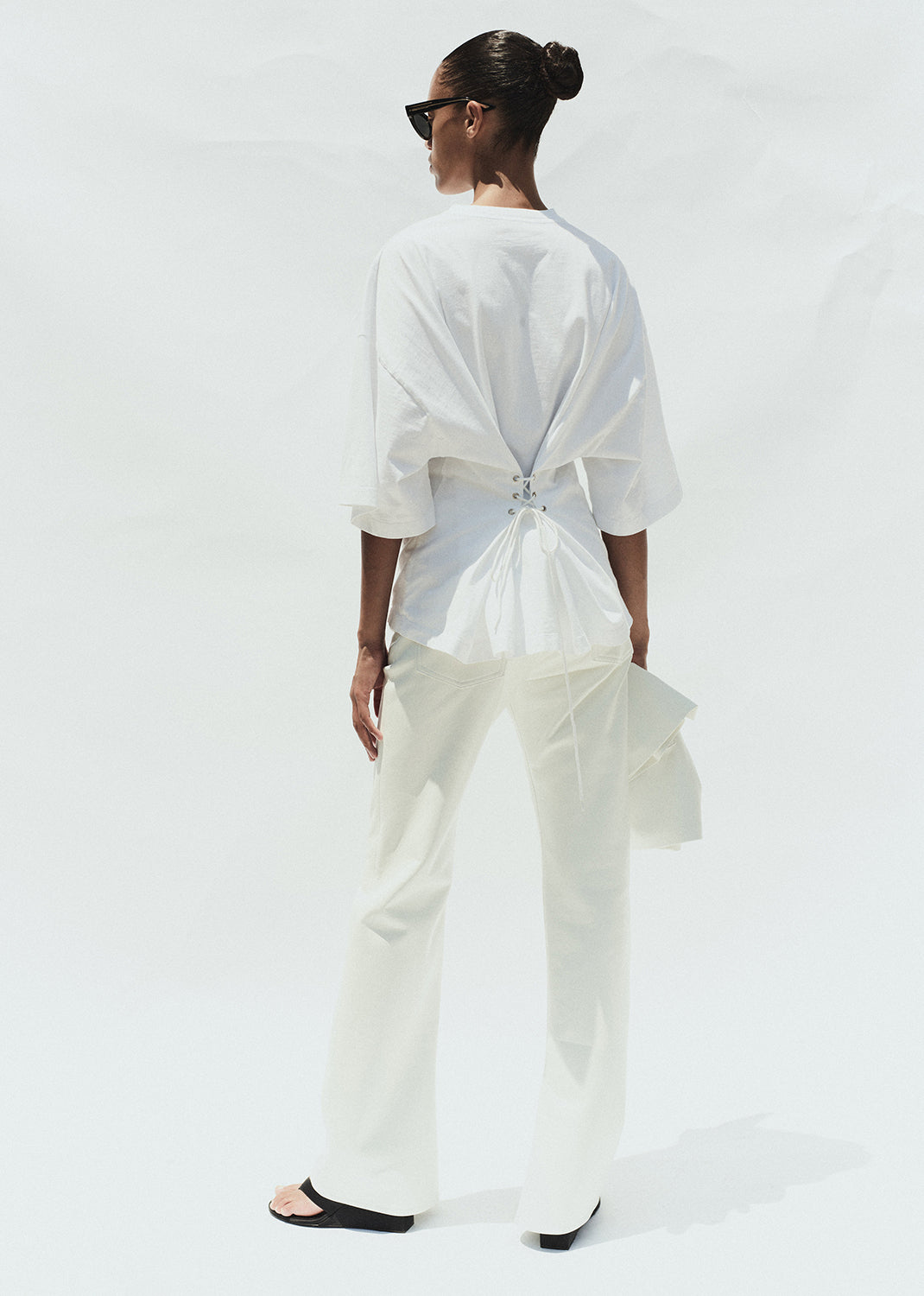 Person wearing a white outfit with a plain background