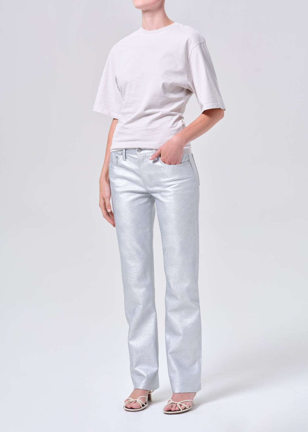 Person wearing a white t-shirt and light blue jeans on a white background