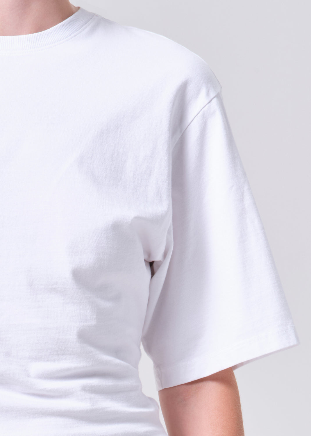 White t-shirt worn by a person on a plain background