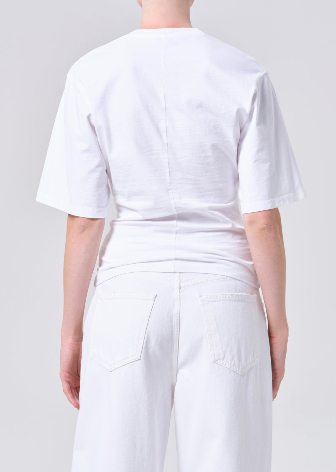 Person wearing a white outfit on a plain background