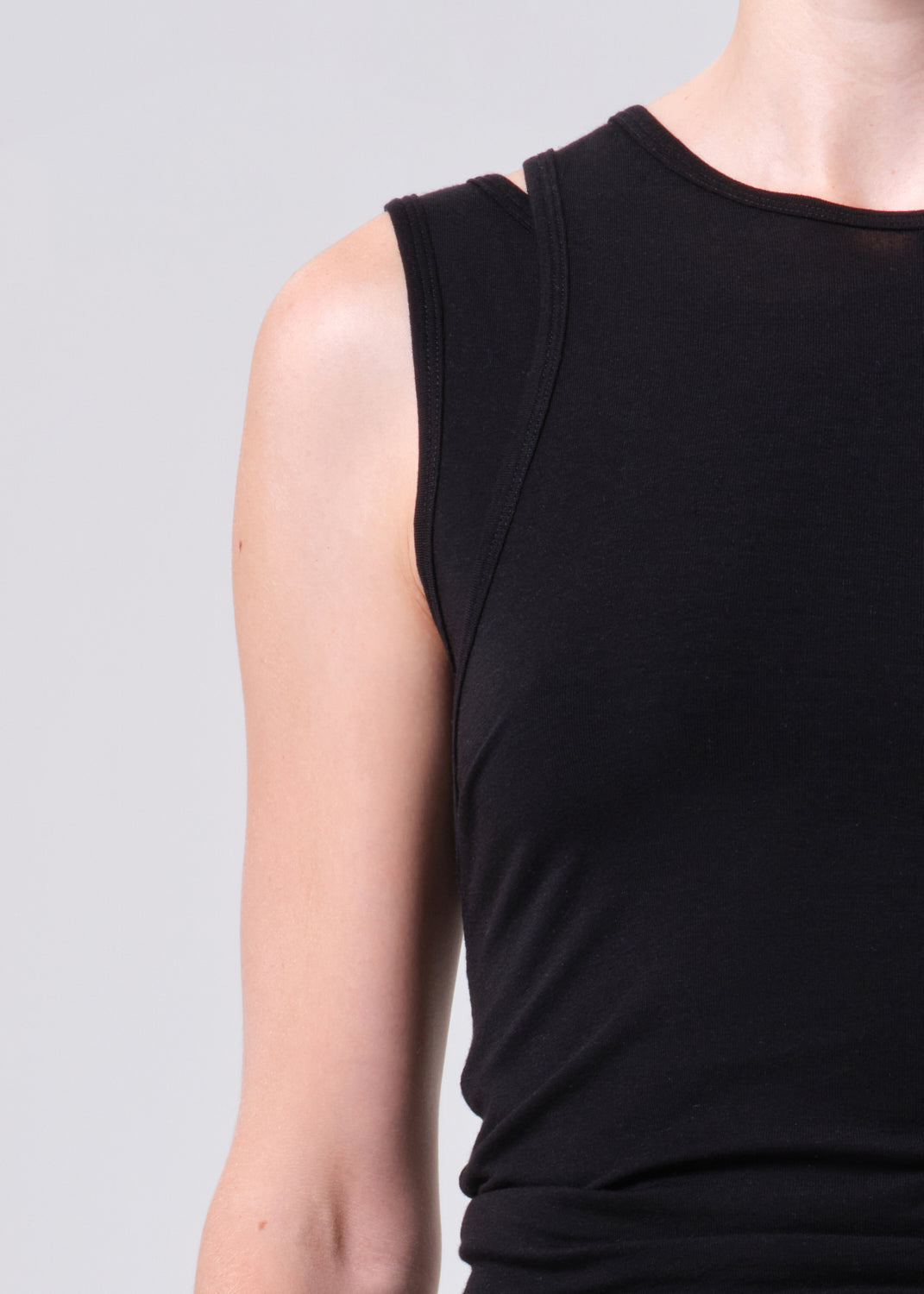 Black sleeveless top worn by a person on a gray background