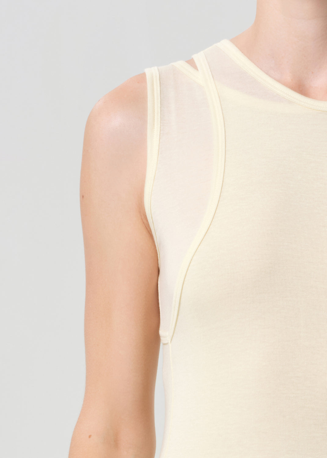 Light yellow sleeveless top on a plain background