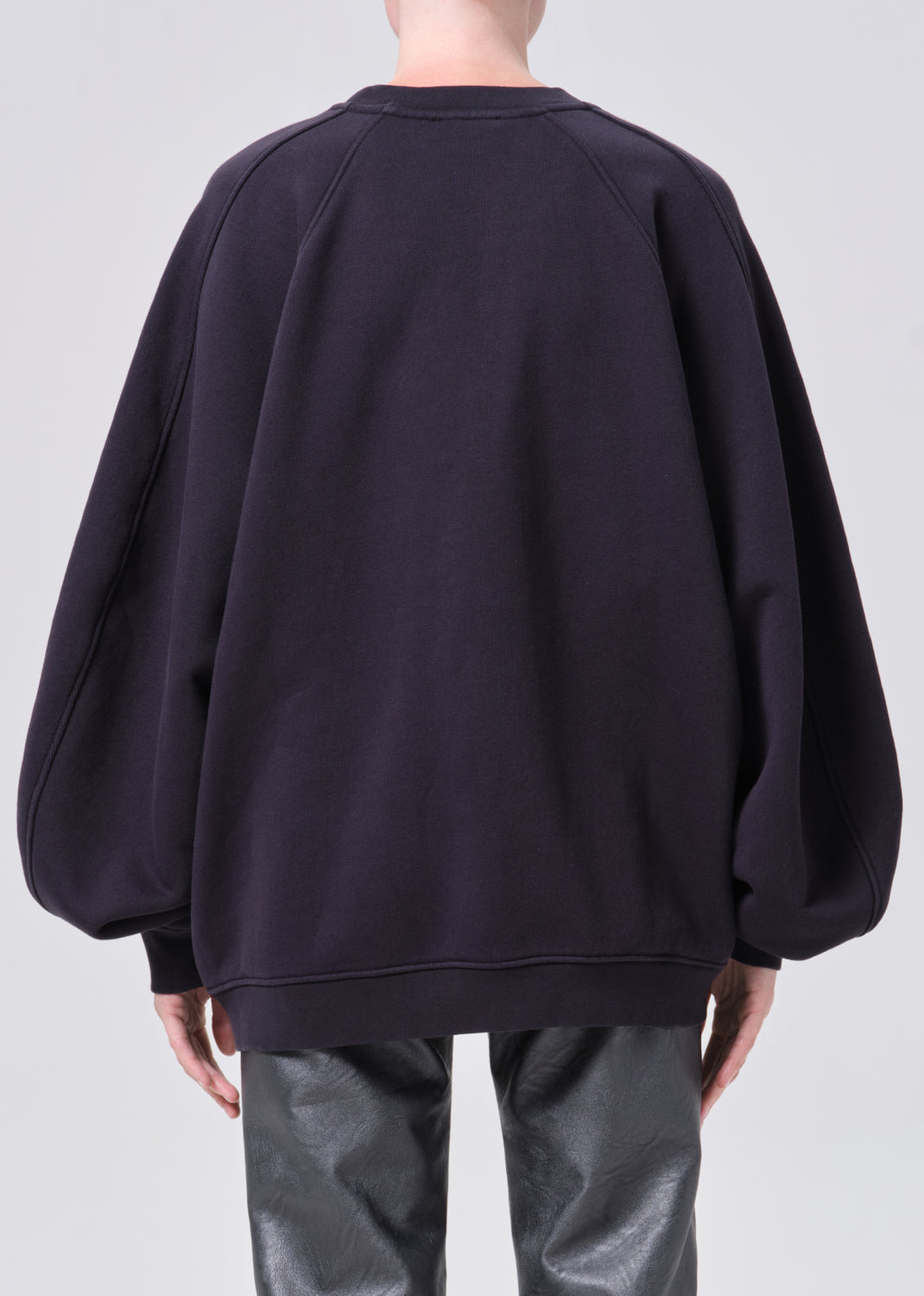 Person wearing a dark blue sweatshirt on a light gray background
