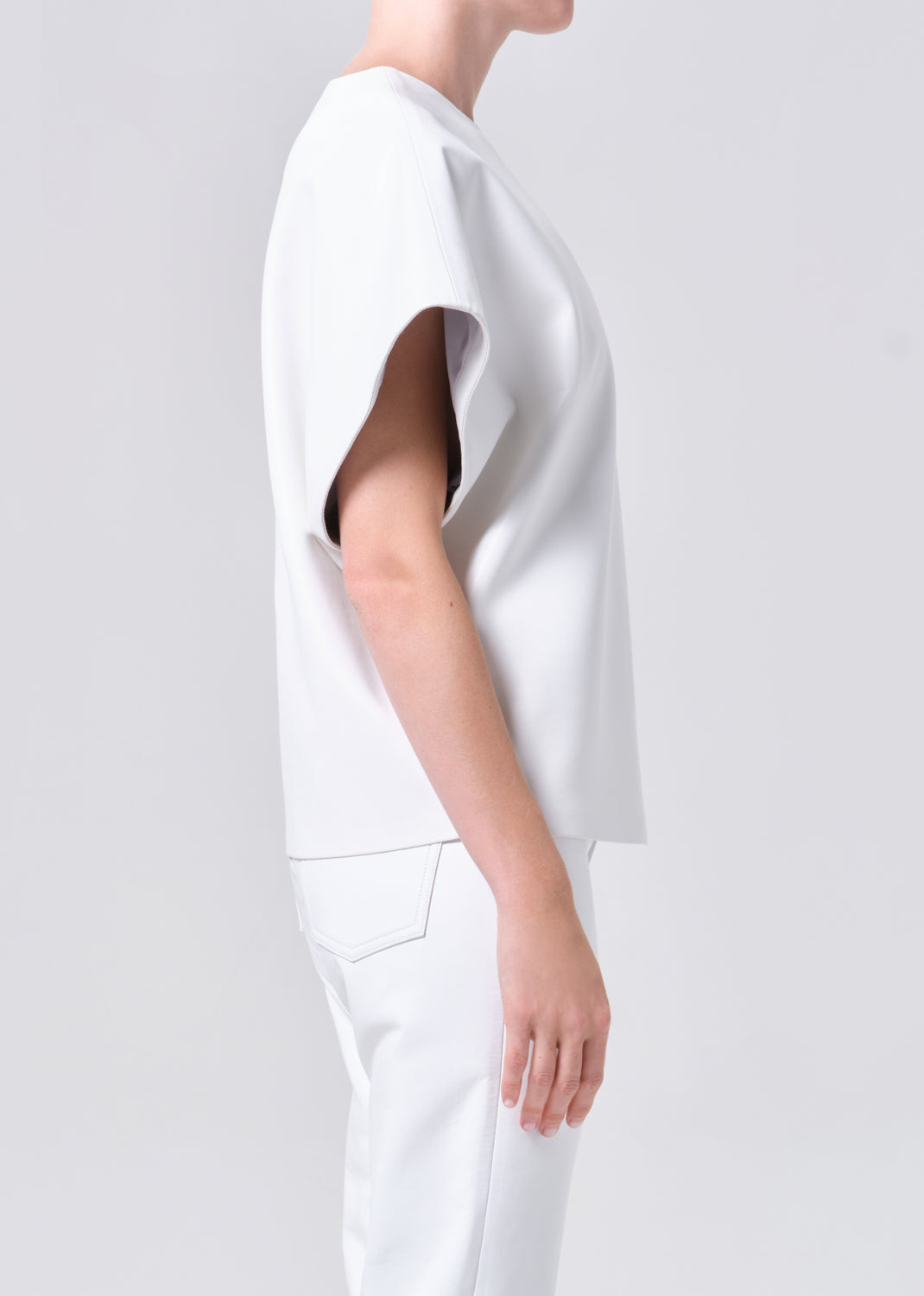 Person wearing a white outfit on a plain background