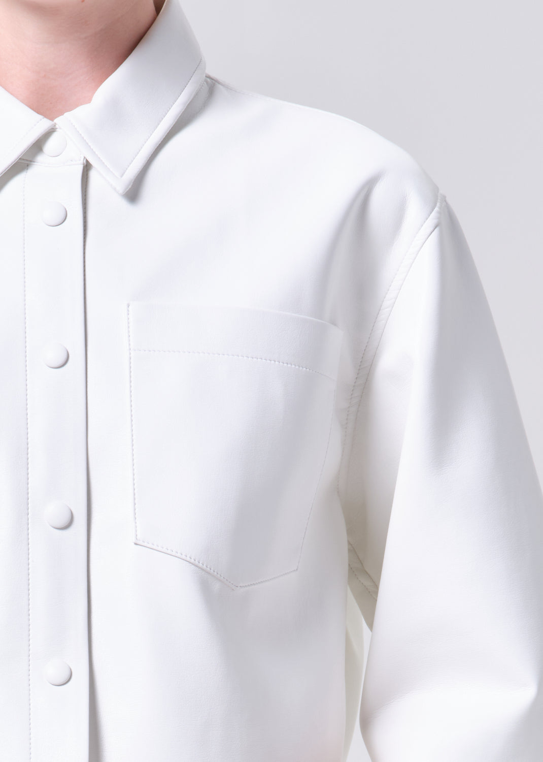 Close-up of a white shirt with buttons on a plain background