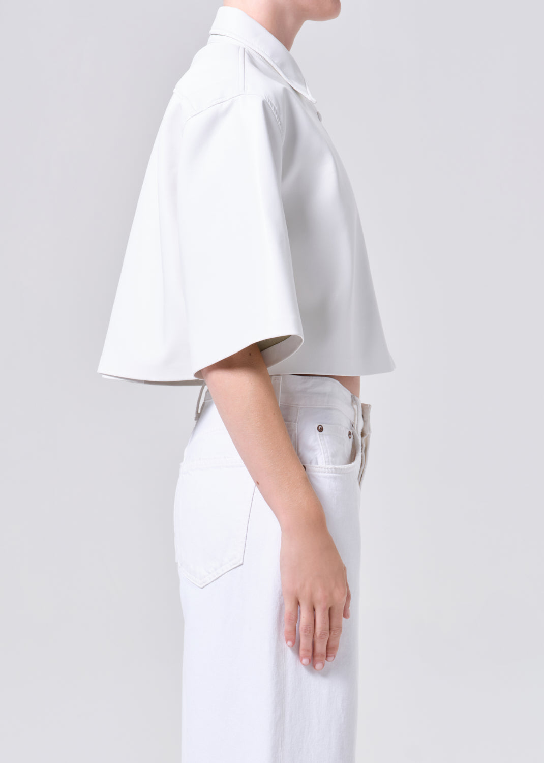 Person wearing a white outfit with a plain background