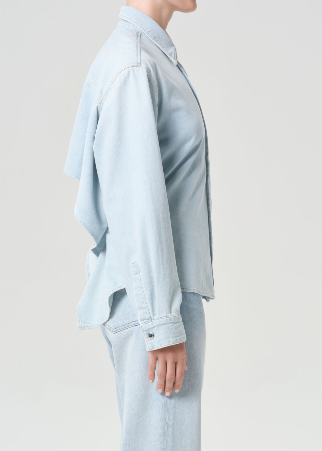 Light blue denim jacket worn by a person on a plain background