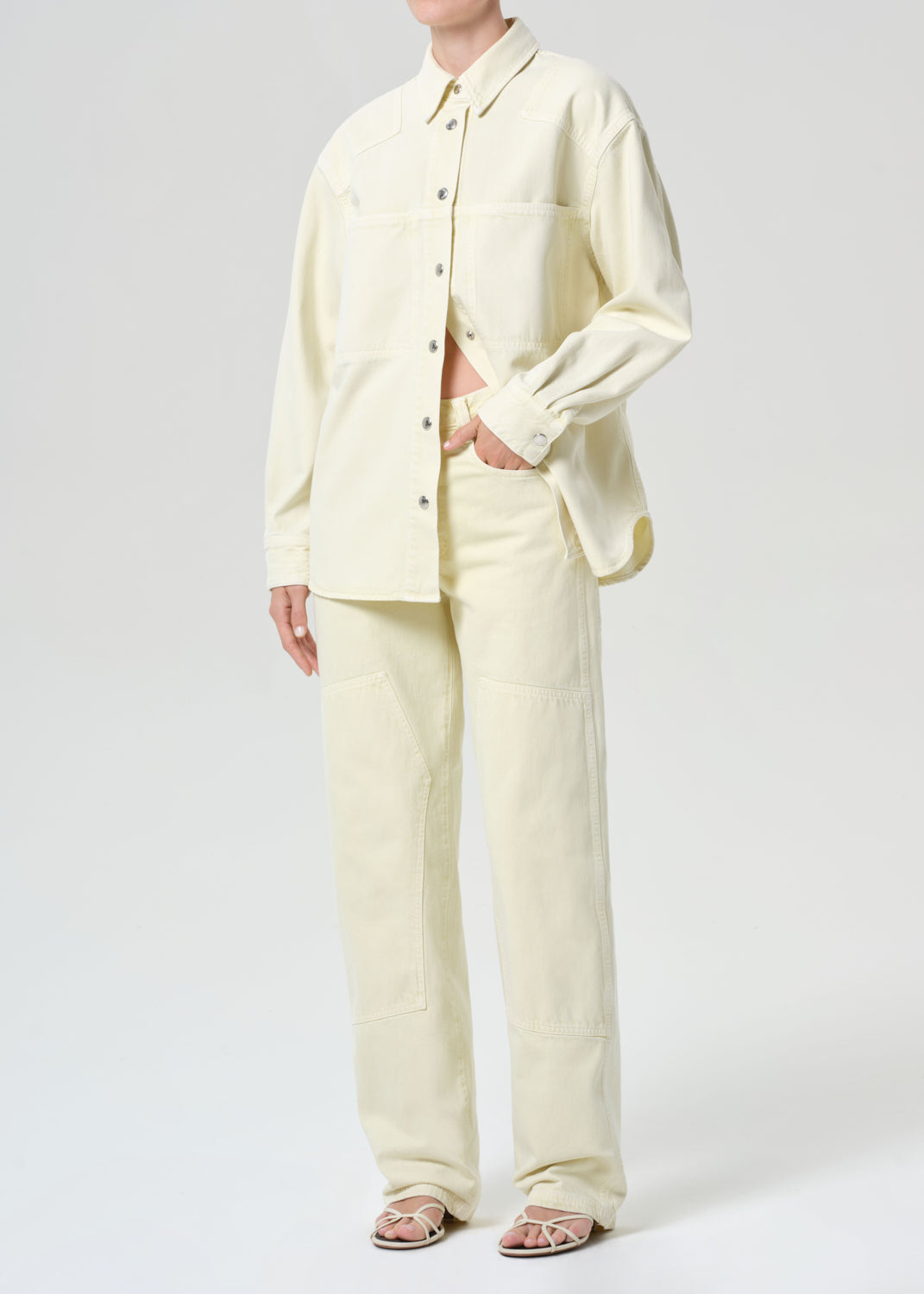 Person wearing a light yellow suit on a white background