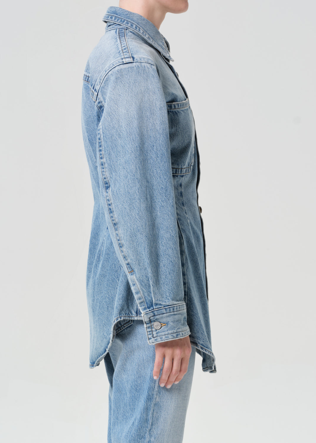 Light blue denim jacket worn by a person on a light gray background
