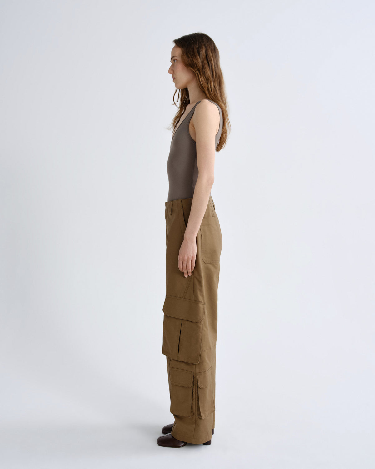 Woman wearing a sleeveless top and cargo pants on a white background