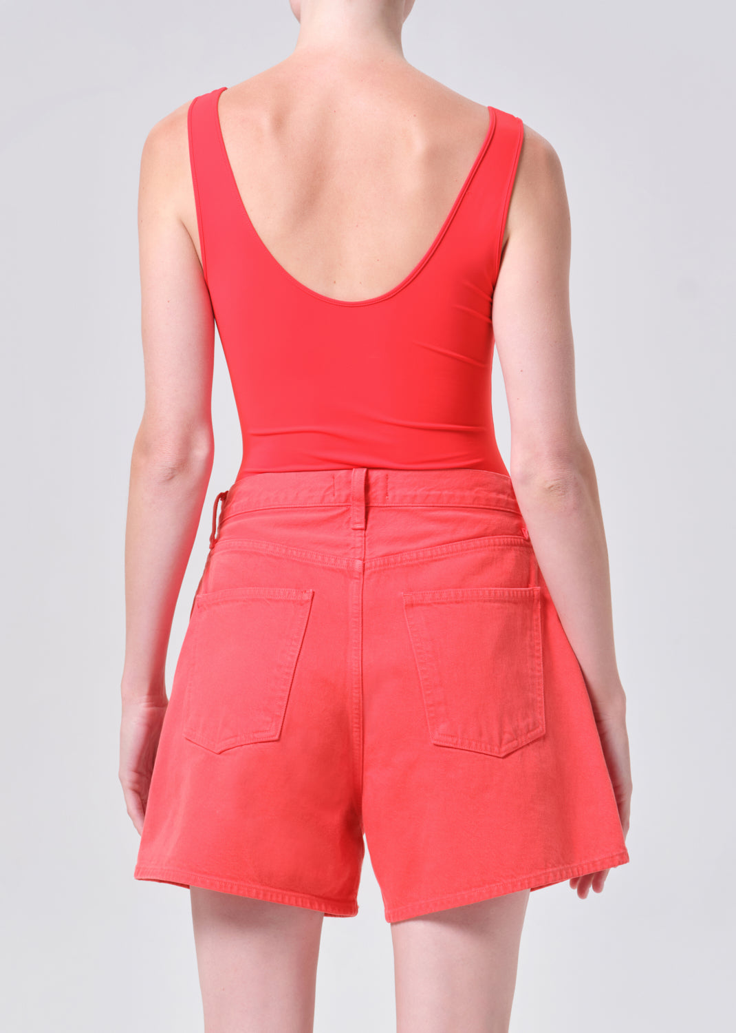 Person wearing a red romper on a plain background