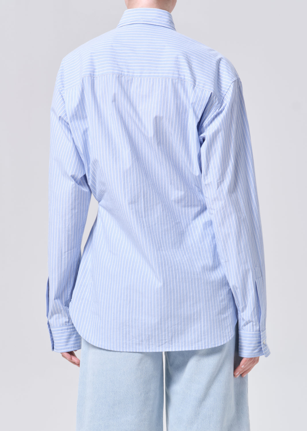 Light blue striped shirt worn by a person on a plain background