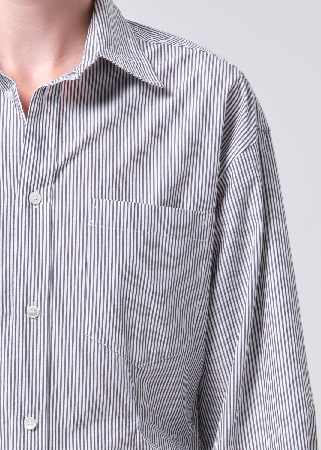 Close-up of a striped shirt with a pocket on a plain background