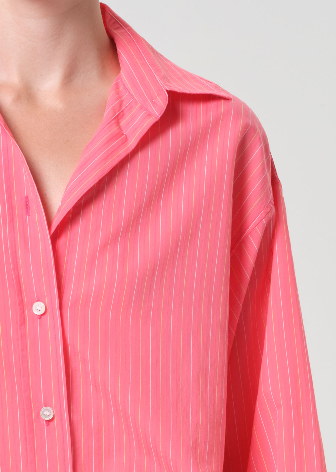 Close-up of a pink striped shirt with a plain background