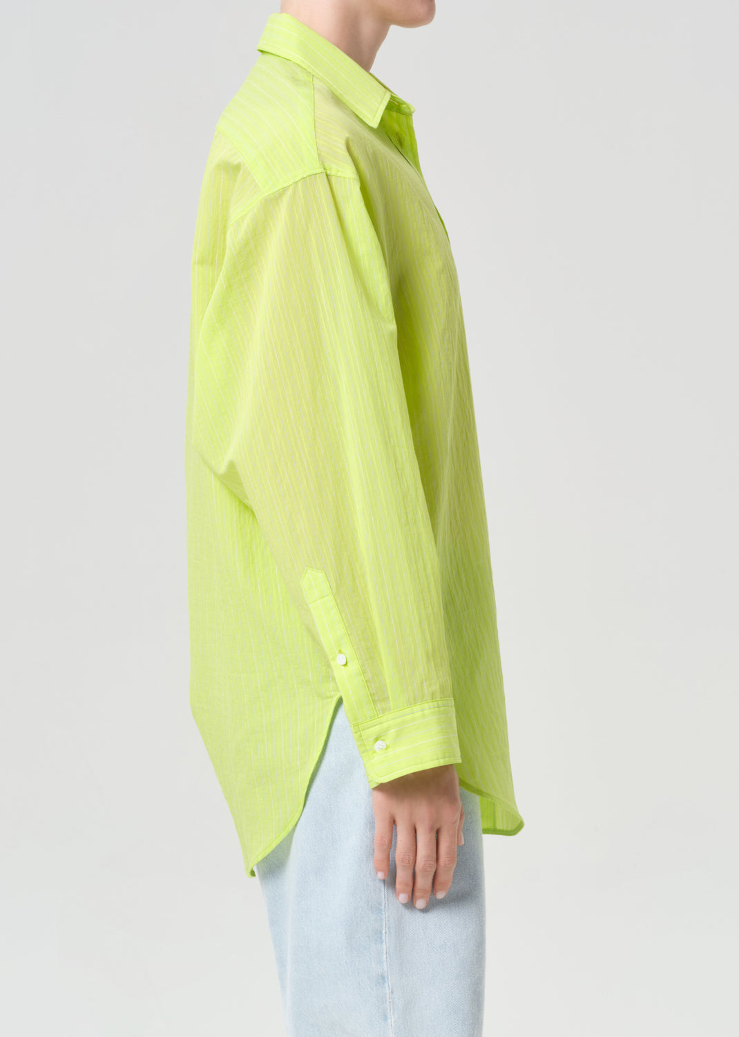 Person wearing a bright green shirt on a plain background