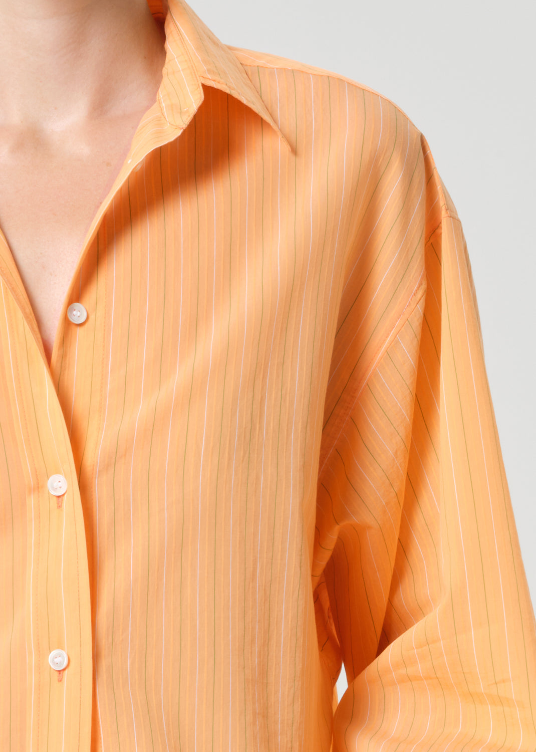 Close-up of an orange striped shirt with a plain background